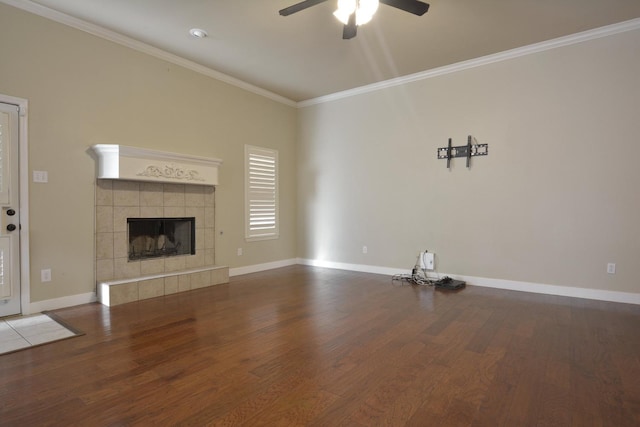 unfurnished living room with a tiled fireplace, wood-type flooring, and ornamental molding