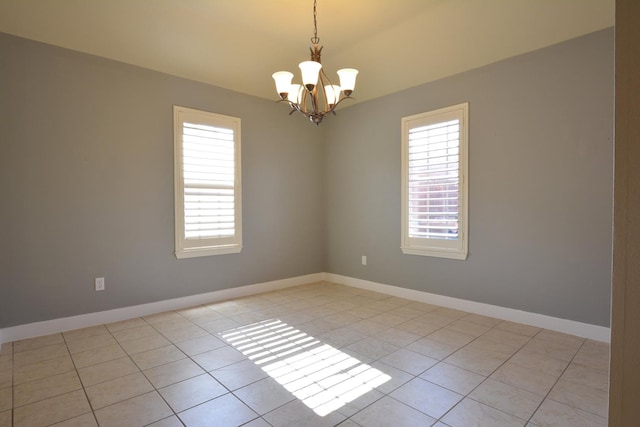 spare room with light tile patterned flooring and an inviting chandelier