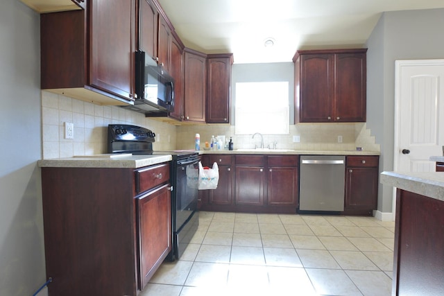 kitchen featuring tasteful backsplash, sink, light tile patterned floors, and black appliances