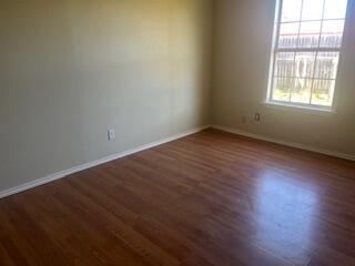 6423 22nd St, Lubbock, TX 79407 - spare room with dark wood-style flooring and baseboards