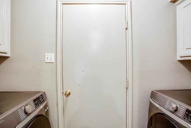 laundry room featuring washing machine and dryer and cabinets