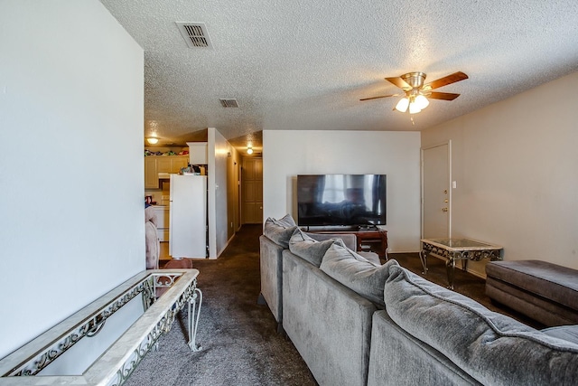 living room with dark colored carpet, ceiling fan, and a textured ceiling