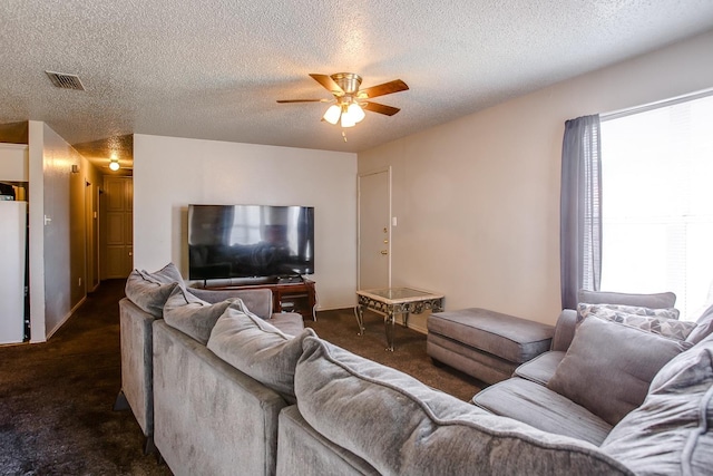 carpeted living room with ceiling fan and a textured ceiling