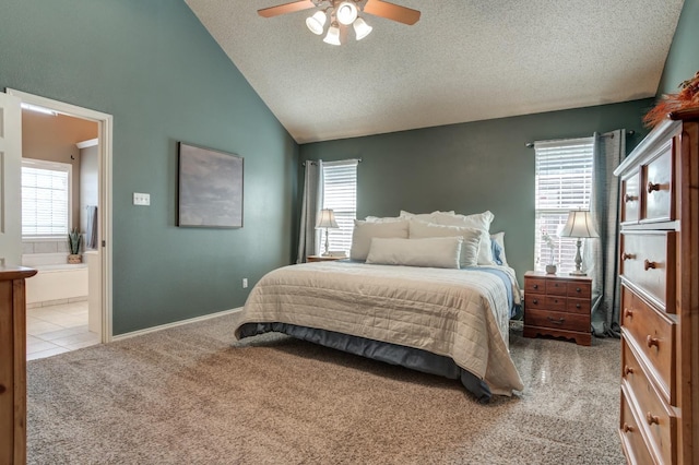 bedroom featuring ensuite bathroom, lofted ceiling, light colored carpet, ceiling fan, and a textured ceiling