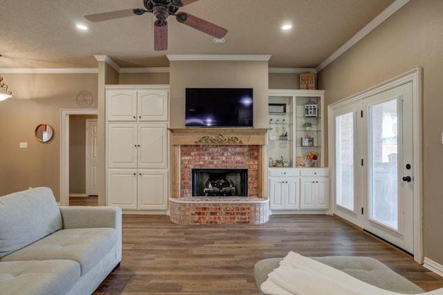 living room featuring crown molding, ceiling fan, hardwood / wood-style floors, and a brick fireplace