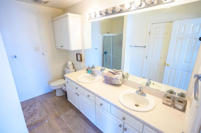 bathroom with vanity, hardwood / wood-style flooring, toilet, and walk in shower