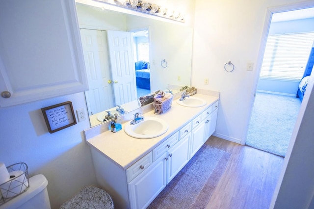 bathroom with hardwood / wood-style flooring, vanity, and toilet