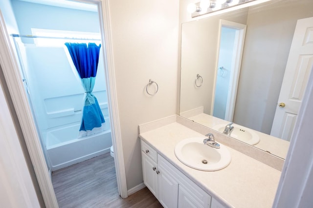 full bathroom featuring hardwood / wood-style flooring, vanity, shower / washtub combination, and toilet