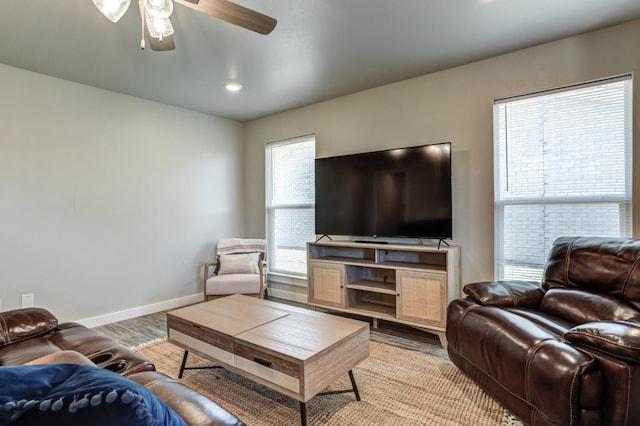 living room with light hardwood / wood-style flooring and ceiling fan