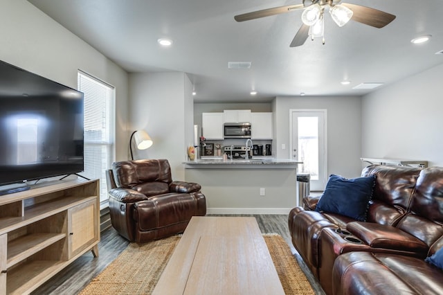 living room with dark wood-type flooring and ceiling fan