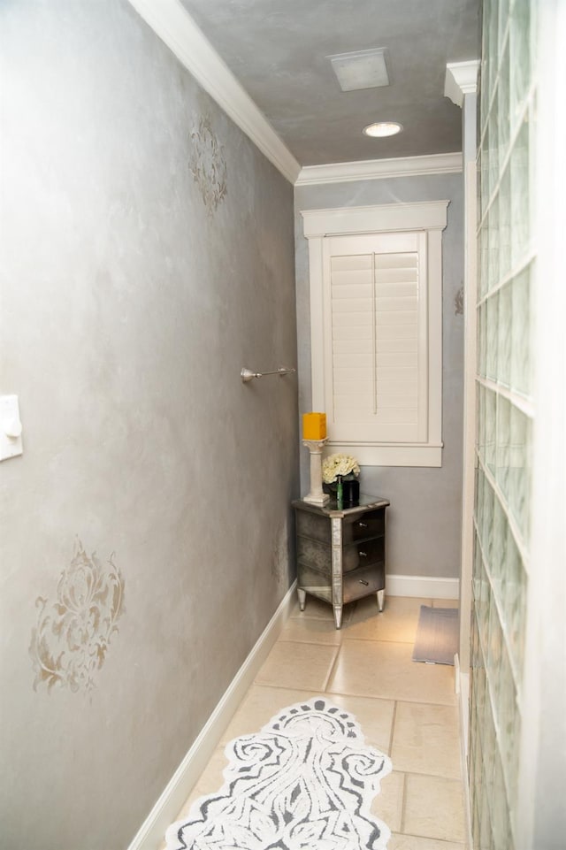 hallway with ornamental molding and light tile patterned floors