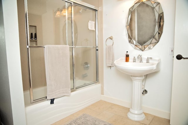 bathroom featuring tile patterned flooring and bath / shower combo with glass door