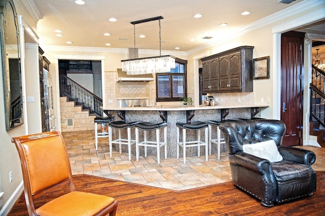 kitchen featuring ornamental molding, backsplash, a kitchen breakfast bar, and kitchen peninsula