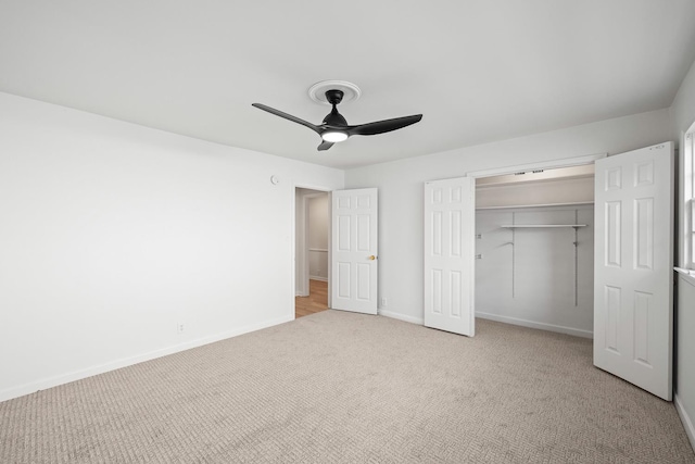 unfurnished bedroom featuring light colored carpet, ceiling fan, and a closet