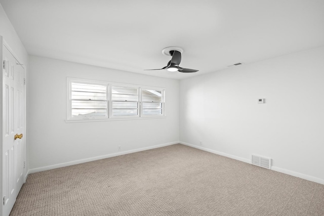 carpeted spare room featuring ceiling fan