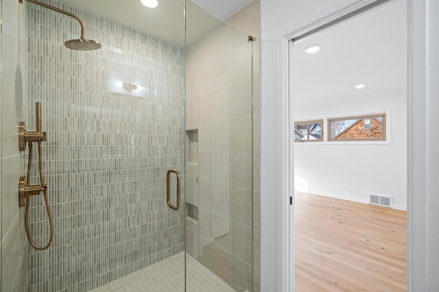 bathroom featuring hardwood / wood-style floors and an enclosed shower