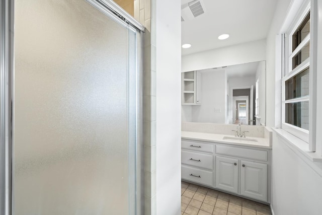 bathroom featuring tile patterned flooring, vanity, and walk in shower