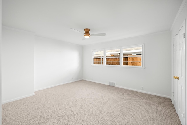 carpeted empty room featuring crown molding and ceiling fan