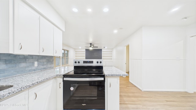 3811 42nd St, Lubbock, TX 79413 - kitchen with stainless steel electric range oven, a peninsula, light wood-style flooring, tasteful backsplash, and white cabinets
