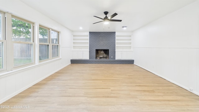 3811 42nd St, Lubbock, TX 79413 - unfurnished living room featuring a ceiling fan, light wood finished floors, a fireplace, and built in shelves