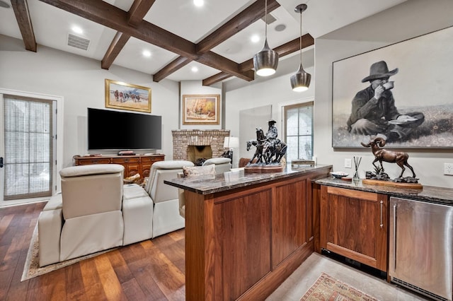 interior space featuring beamed ceiling, a brick fireplace, and dark hardwood / wood-style flooring