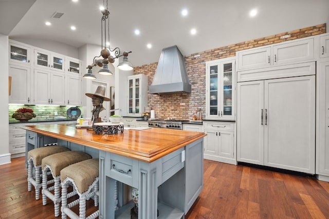 kitchen with premium range hood, butcher block counters, and white cabinets