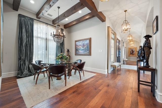 dining space with beamed ceiling, dark wood-type flooring, and a notable chandelier