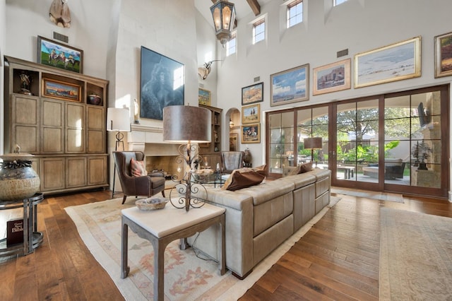 living room featuring a towering ceiling and hardwood / wood-style floors