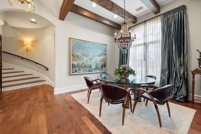 dining room with beamed ceiling, an inviting chandelier, and hardwood / wood-style flooring