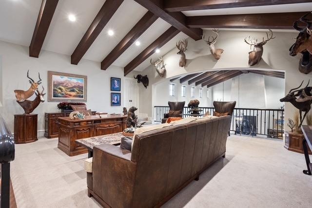 living room featuring lofted ceiling with beams and light colored carpet