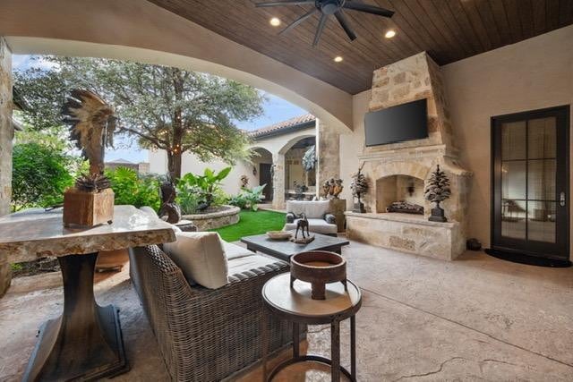 view of patio featuring ceiling fan and an outdoor stone fireplace