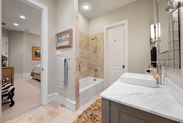 bathroom with tiled shower / bath and vanity