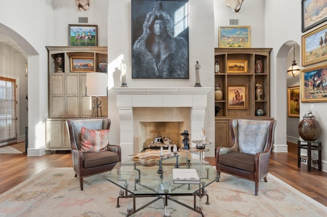 living area featuring a tiled fireplace and hardwood / wood-style floors