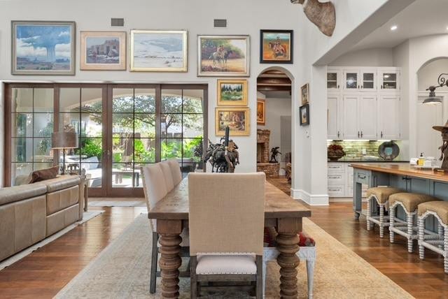 dining room with dark wood-type flooring and a high ceiling