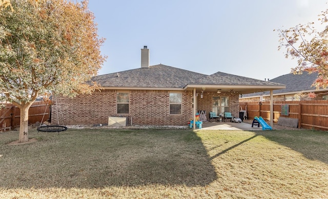 rear view of house with a lawn and a patio