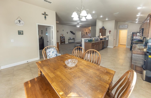 tiled dining area featuring lofted ceiling and ceiling fan with notable chandelier