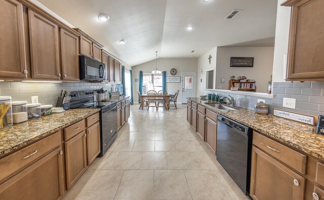 kitchen with sink, vaulted ceiling, black appliances, and stone counters