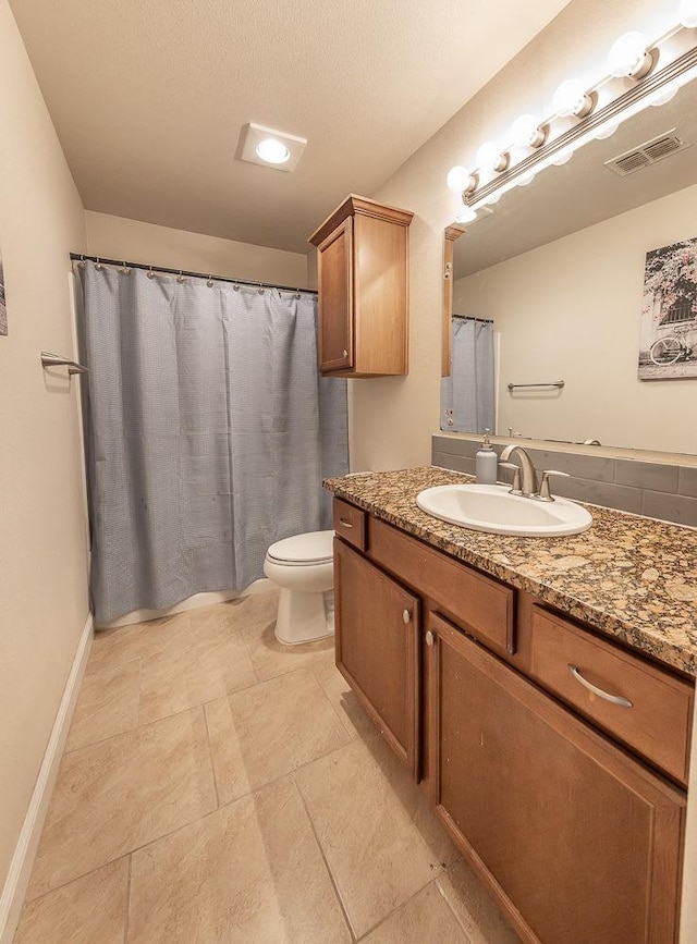 bathroom with vanity, toilet, and a textured ceiling