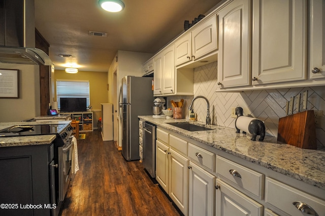 5309 77th St, Lubbock, TX 79424 - kitchen featuring appliances with stainless steel finishes, wall chimney exhaust hood, a sink, light stone counters, and backsplash