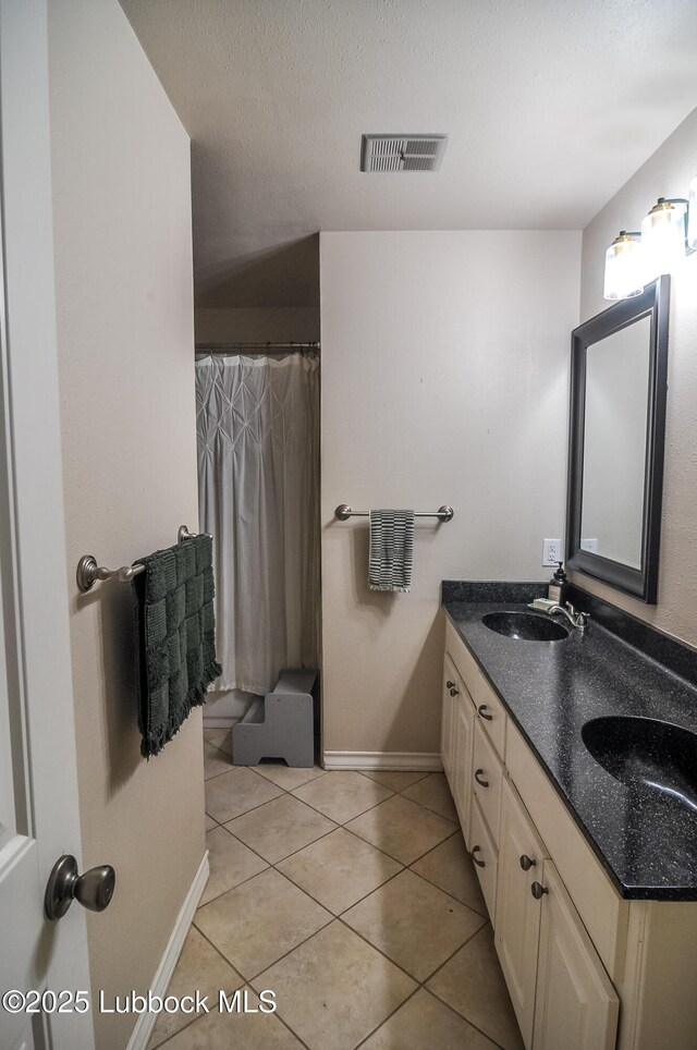 5309 77th St, Lubbock, TX 79424 - bathroom featuring double vanity, baseboards, tile patterned flooring, a shower with curtain, and a textured ceiling