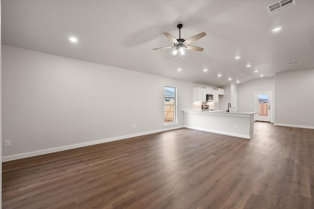 unfurnished living room featuring vaulted ceiling, sink, ceiling fan, and dark hardwood / wood-style flooring