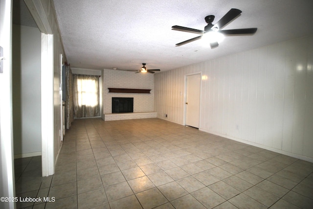 3707 38th St, Lubbock, TX 79413 - unfurnished living room featuring ceiling fan, tile patterned flooring, a fireplace, and a textured ceiling