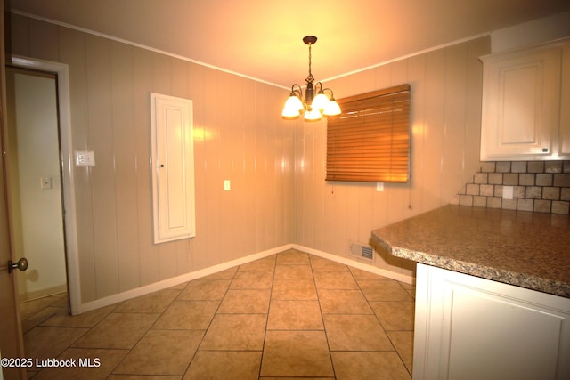 3707 38th St, Lubbock, TX 79413 - unfurnished dining area with a chandelier, light tile patterned floors, and crown molding