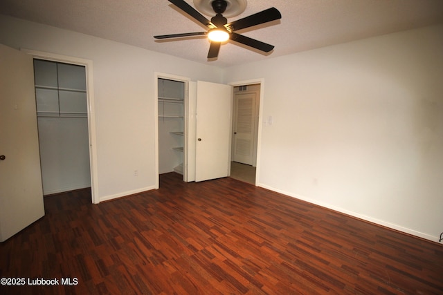 3707 38th St, Lubbock, TX 79413 - unfurnished bedroom featuring two closets, wood finished floors, and a ceiling fan