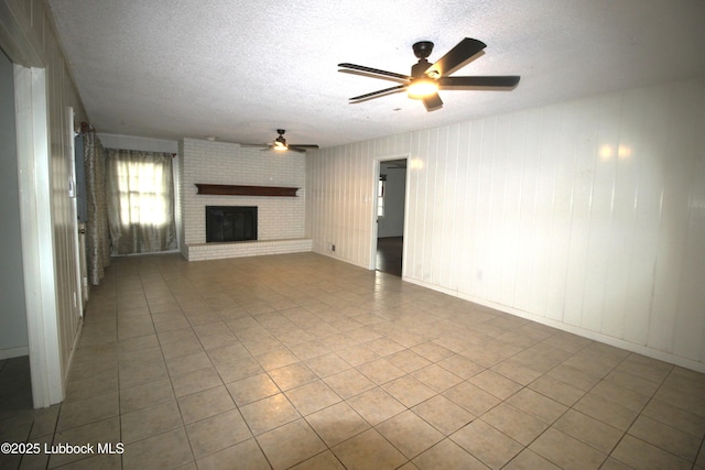 3707 38th St, Lubbock, TX 79413 - unfurnished living room featuring a textured ceiling, ceiling fan, a fireplace, and tile patterned floors