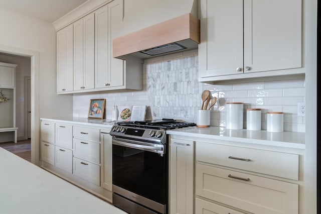 kitchen featuring tasteful backsplash, white cabinetry, dark hardwood / wood-style flooring, custom exhaust hood, and gas stove