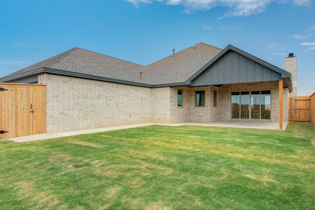 rear view of property with a yard and a patio area