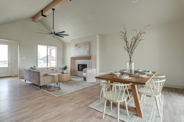 dining space featuring high vaulted ceiling, beam ceiling, light hardwood / wood-style floors, and ceiling fan