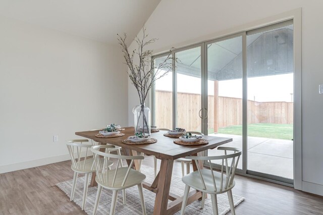 dining room featuring light hardwood / wood-style floors and vaulted ceiling