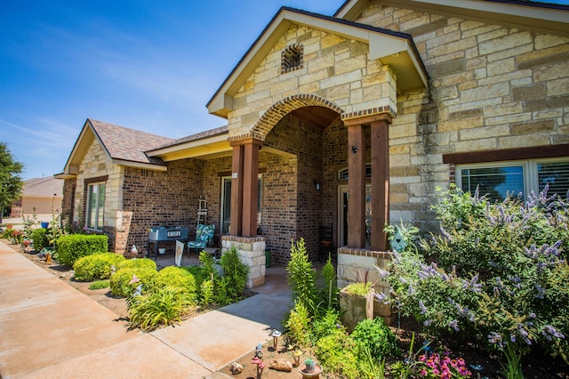 property entrance featuring stone siding and brick siding
